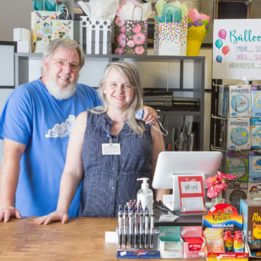 man and woman behind store counter