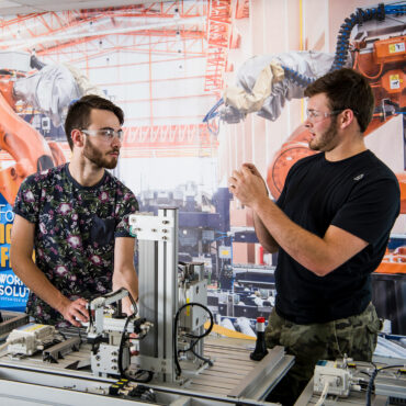 two men talking in robotics lab