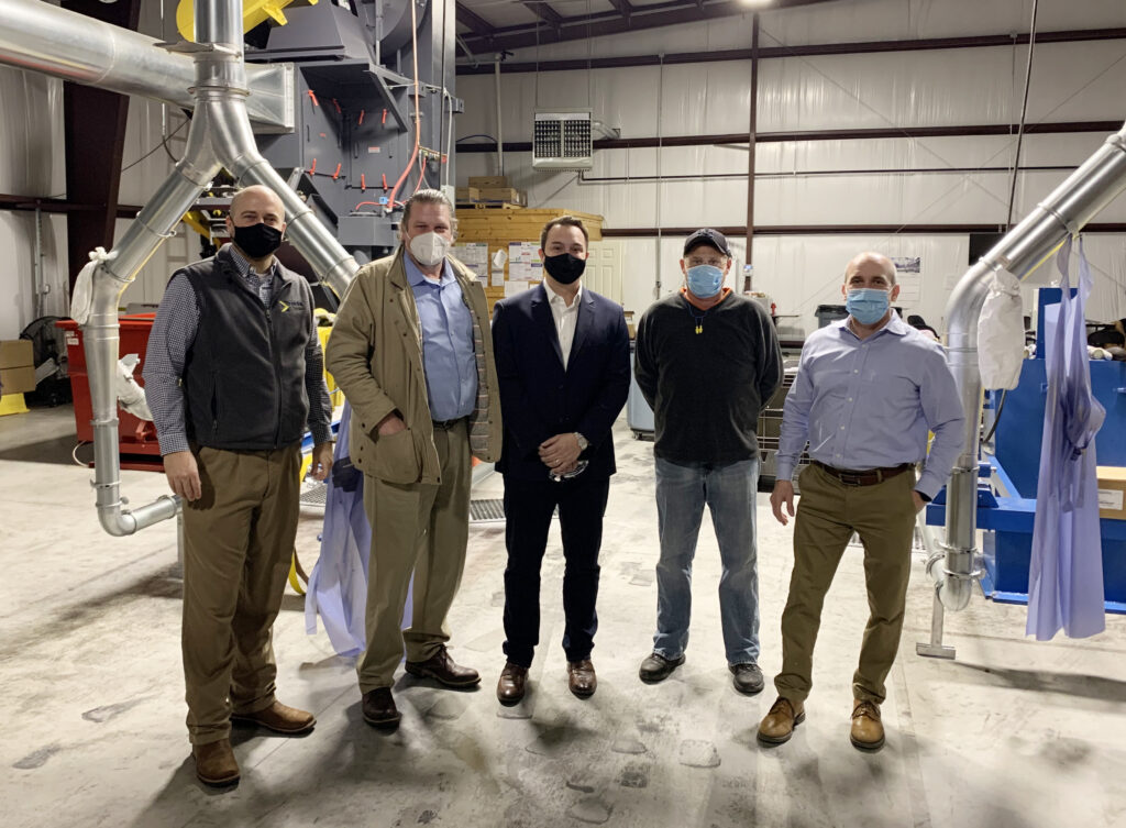 five men standing in a warehouse