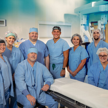 group of doctors and nurses standing in operating room