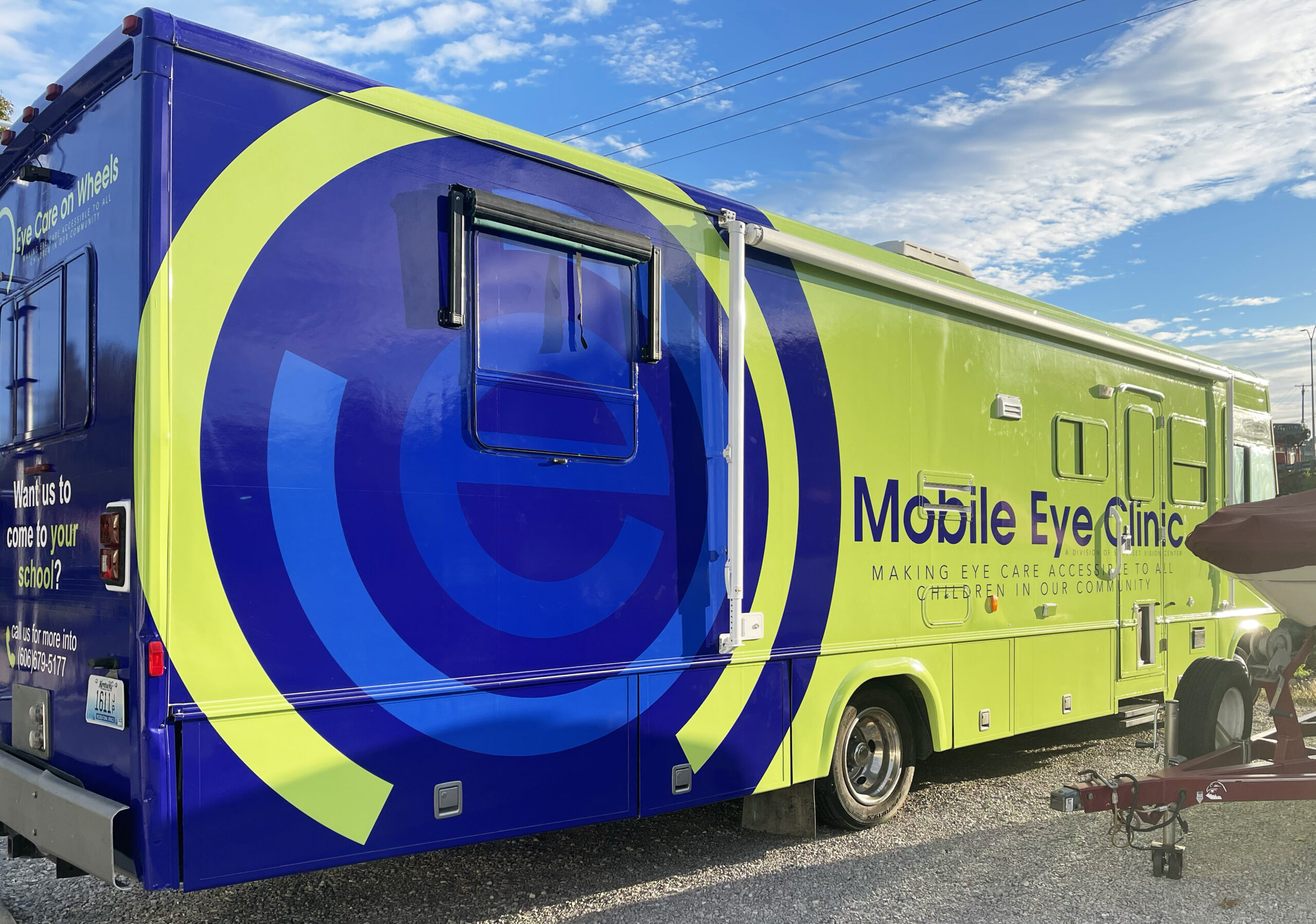 Recreational vehicle wrapped in blue and green graphics promoting mobile eye care unit